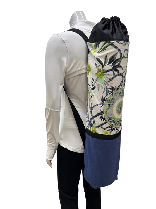 Person wearing a floral drawstring bag over shoulder with a white background