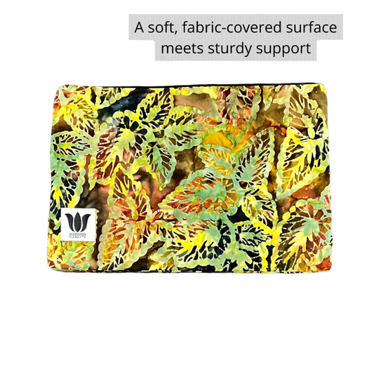 Colorful fabric-covered yoga pilates support block on a gray surface with text overlay