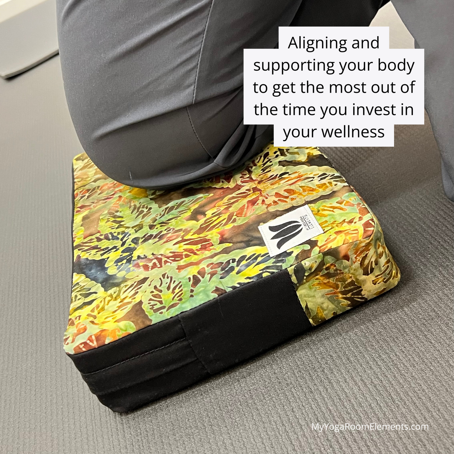Yoga block with colorful design and text on a gray surface