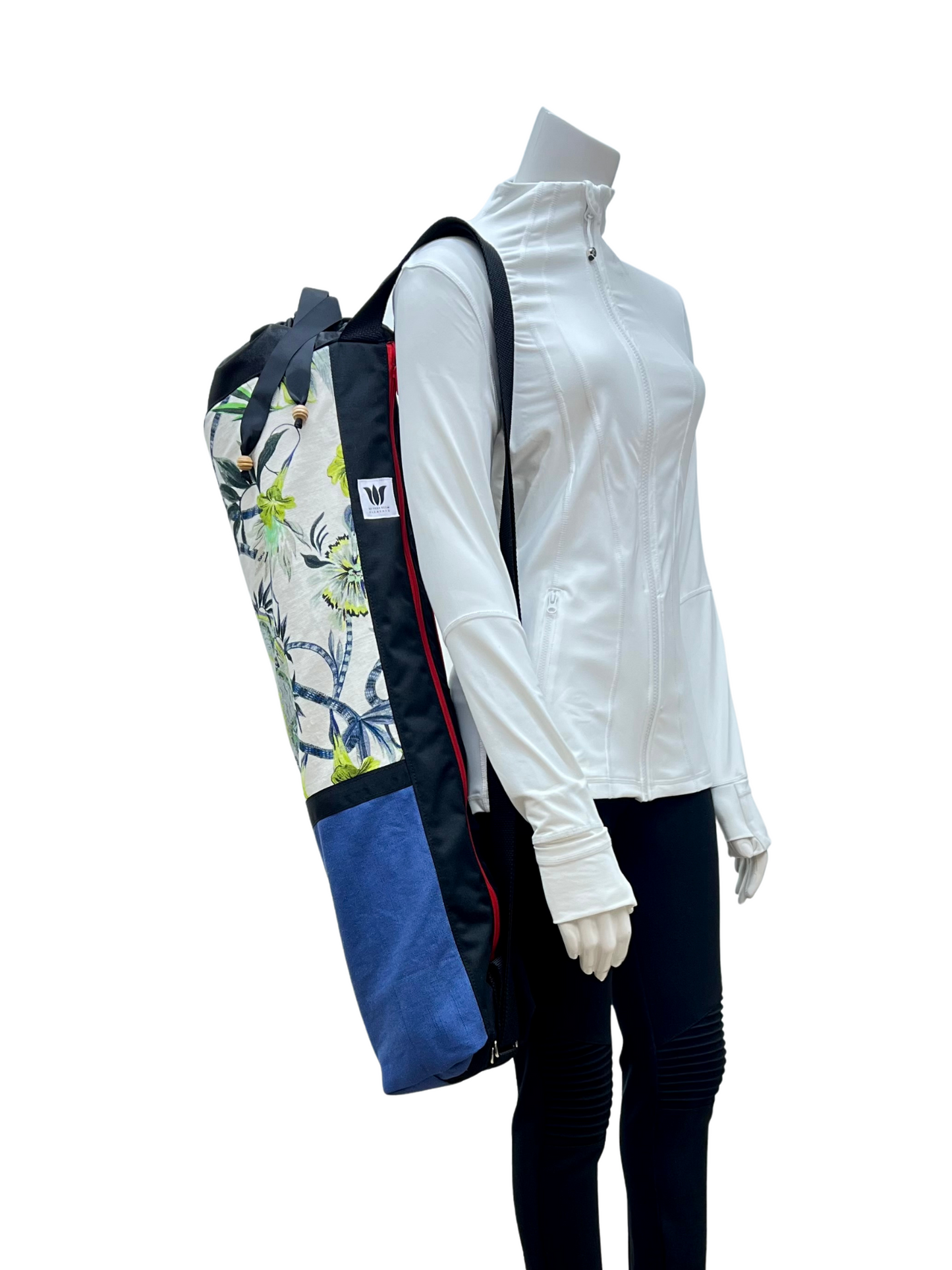 Mannequin wearing a white jacket with a colorful bag over its shoulder on a white background