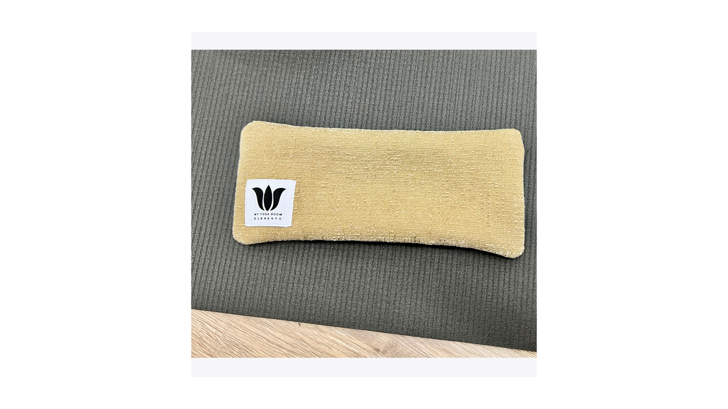 Beige pillow with a logo on a gray surface