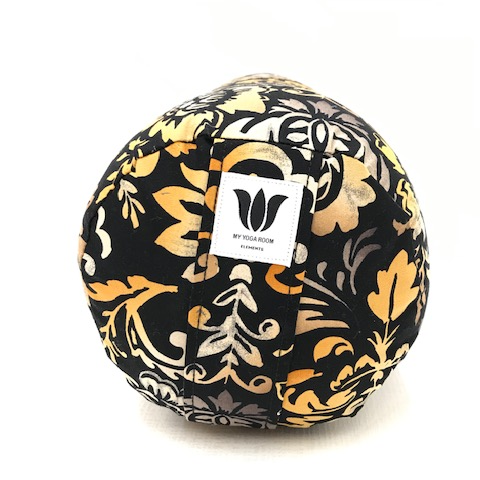 round yoga bolster, made in calgary alberta canada, black background with orange and gold nature pattern