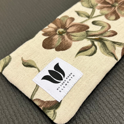Floral-patterned pouch with a brand label on a textured surface
