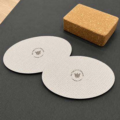 Two yoga pads and a cork block on a dark surface
