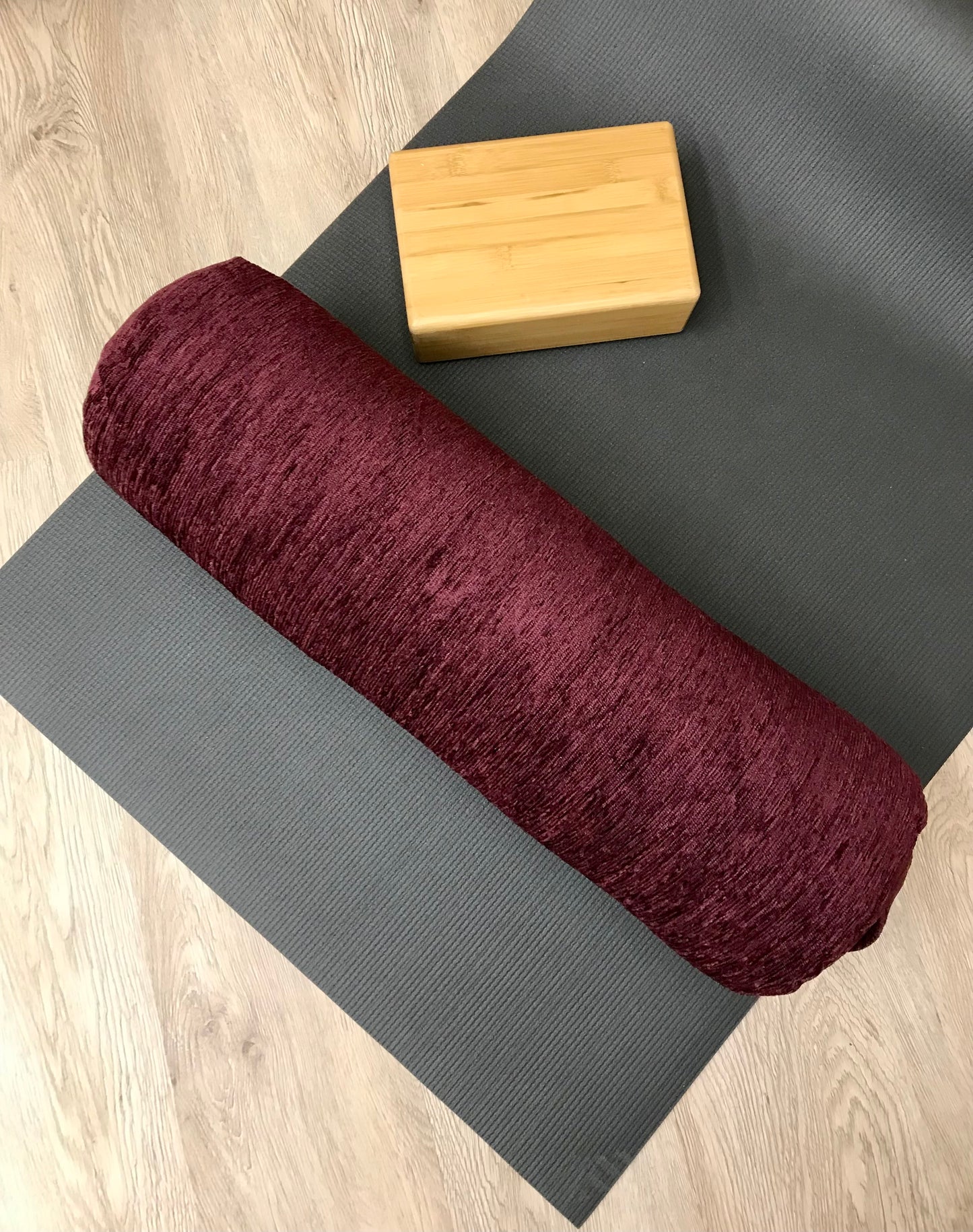 Round yoga bolster in durable plush, dark purple solid print fabric. Allergy conscious fill with removeable cover. Made in Canada by My Yoga Room Elements