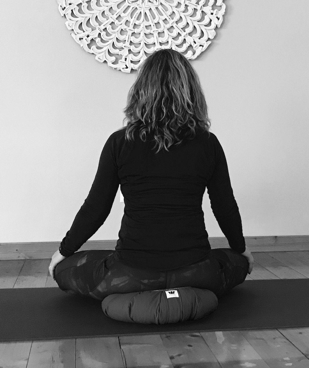 My Yoga Room Elements founder Ellen Wolfe showing seated posture on handcrafted Meditation Seat Cushion
